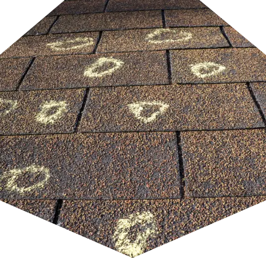 A roof damaged by hail and marked with chalk