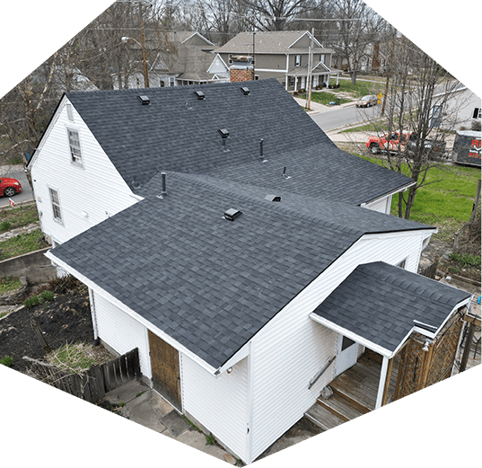 asphalt shingle roof on a white house as a residential roofing services project