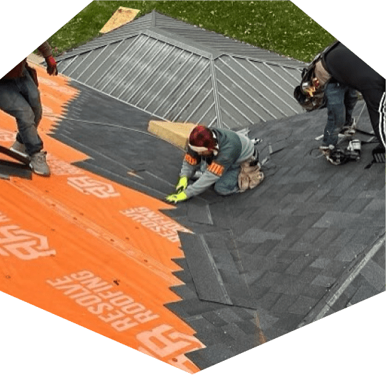 Workers installing shingles on roof