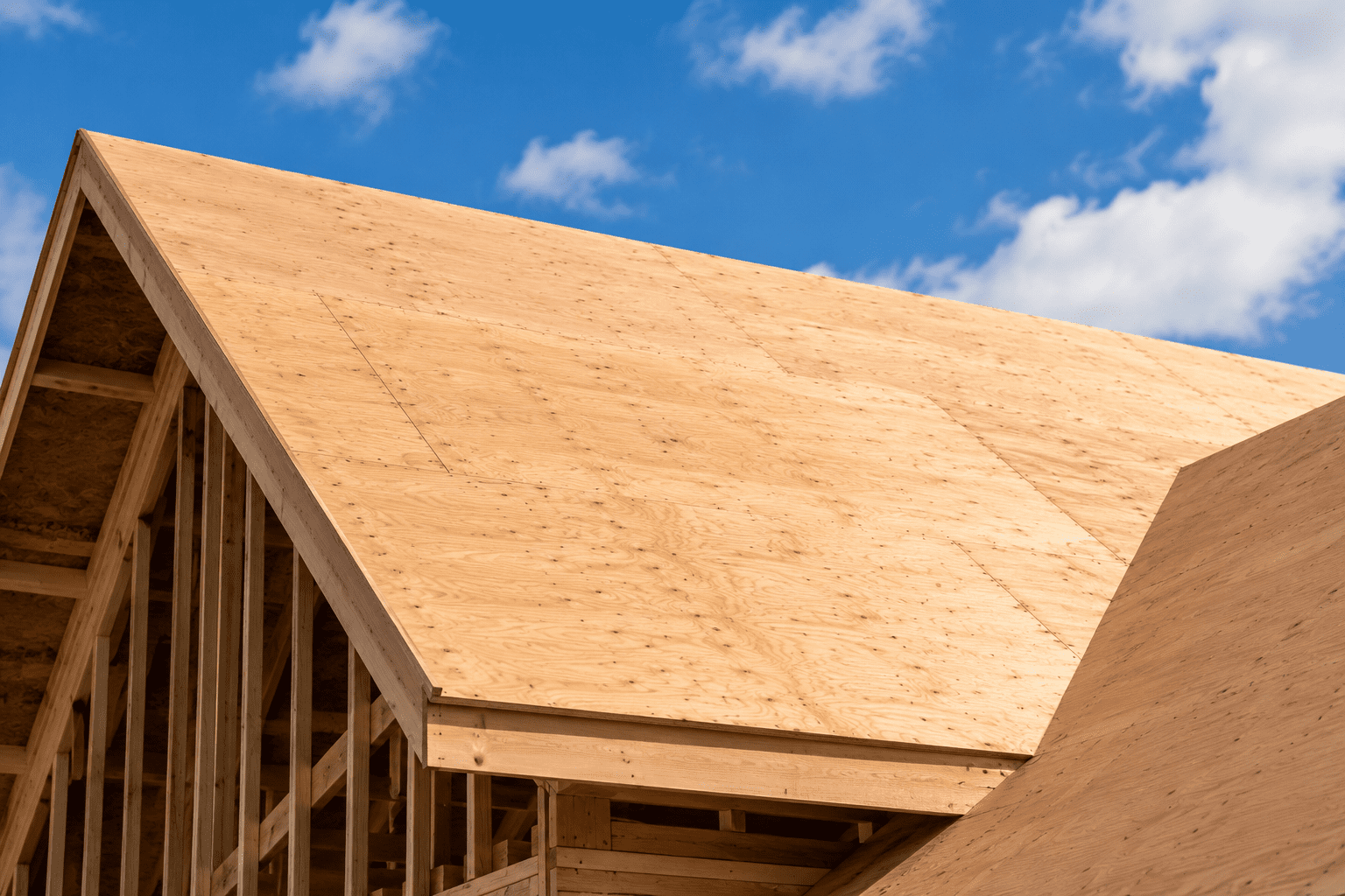 Roof decking exposed on a roof during a roof replacement, prompting the question "What is the process of replacing roof decking​?"